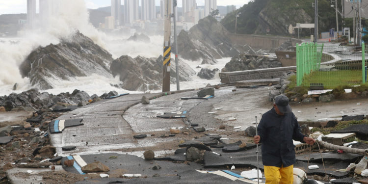 A man walks on a road along the coast damaged by Typhoon Hinnamnor in Ulsan, South Korea, September 6, 2022.    Yonhap via REUTERS   ATTENTION EDITORS - THIS IMAGE HAS BEEN SUPPLIED BY A THIRD PARTY. SOUTH KOREA OUT. NO RESALES. NO ARCHIVE.     TPX IMAGES OF THE DAY